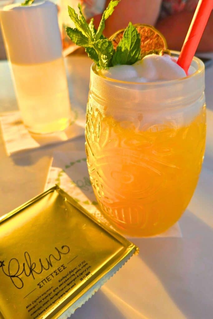 A fruity orange cocktail with a mint spring on the top