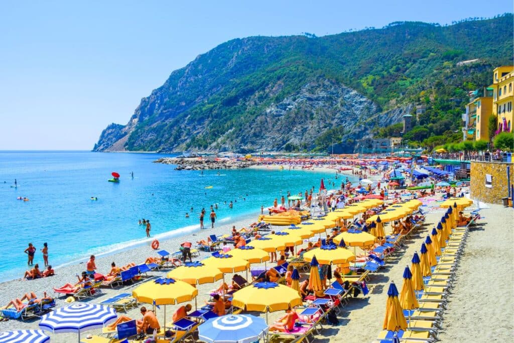 Yellow umbrellas line the beach of Monterosso al Mare in Cinque Terre Italy