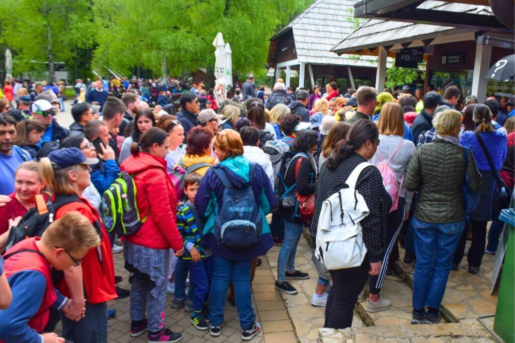 A mass crowd of people shoulder to shoulder at the entrance to Plitvice Lakes